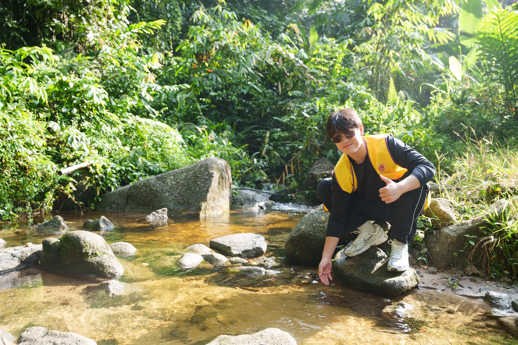Louie pausing beside a clear stream near the village