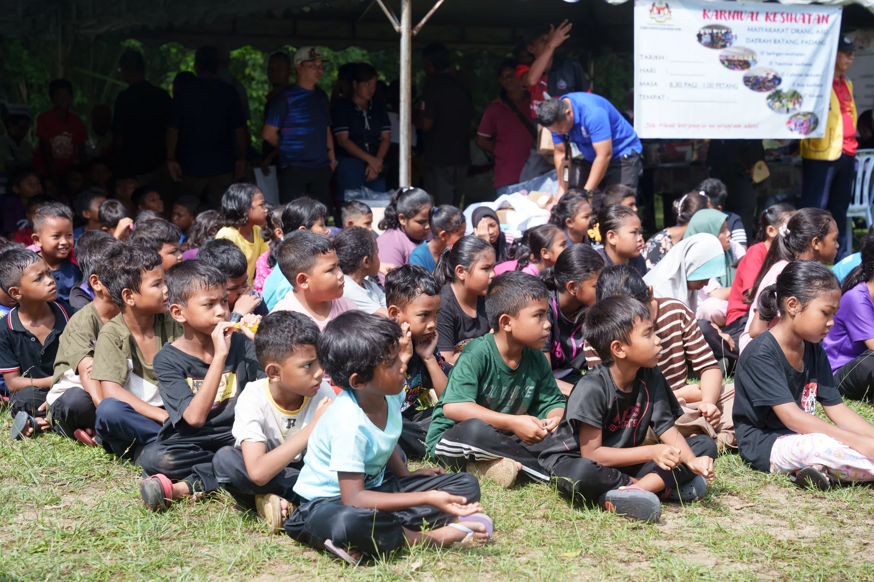 Village children seated together for the health and education programme