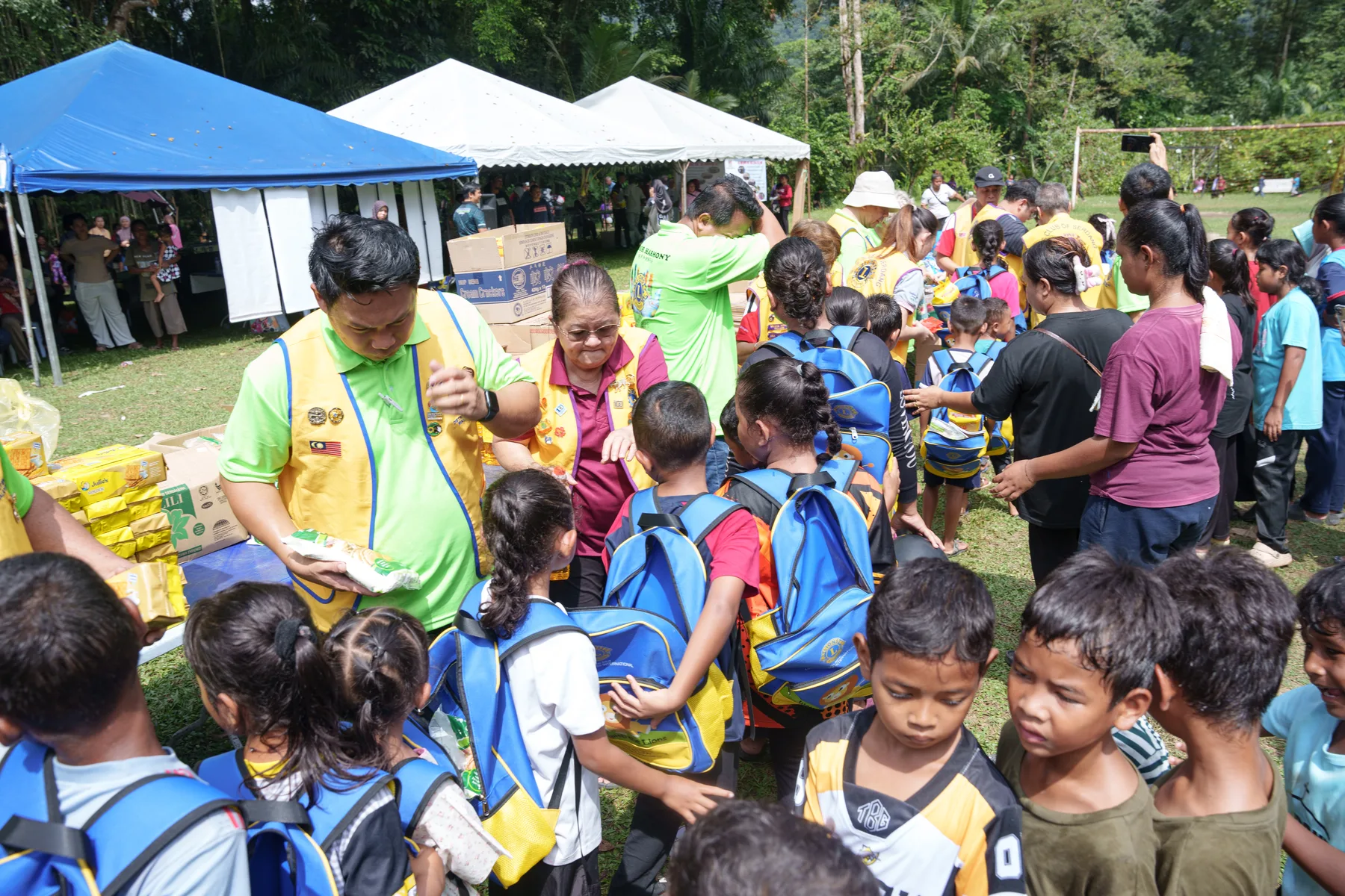 Children collecting supplies from volunteers at the outreach tents