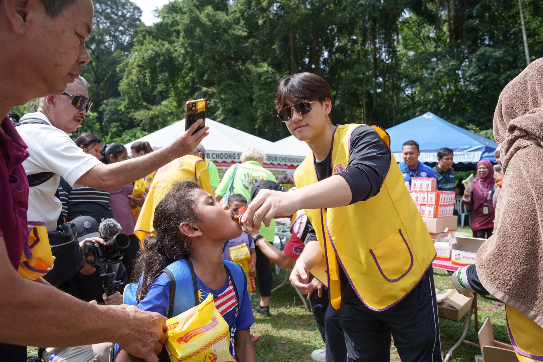 Louie helping a child during the community health programme