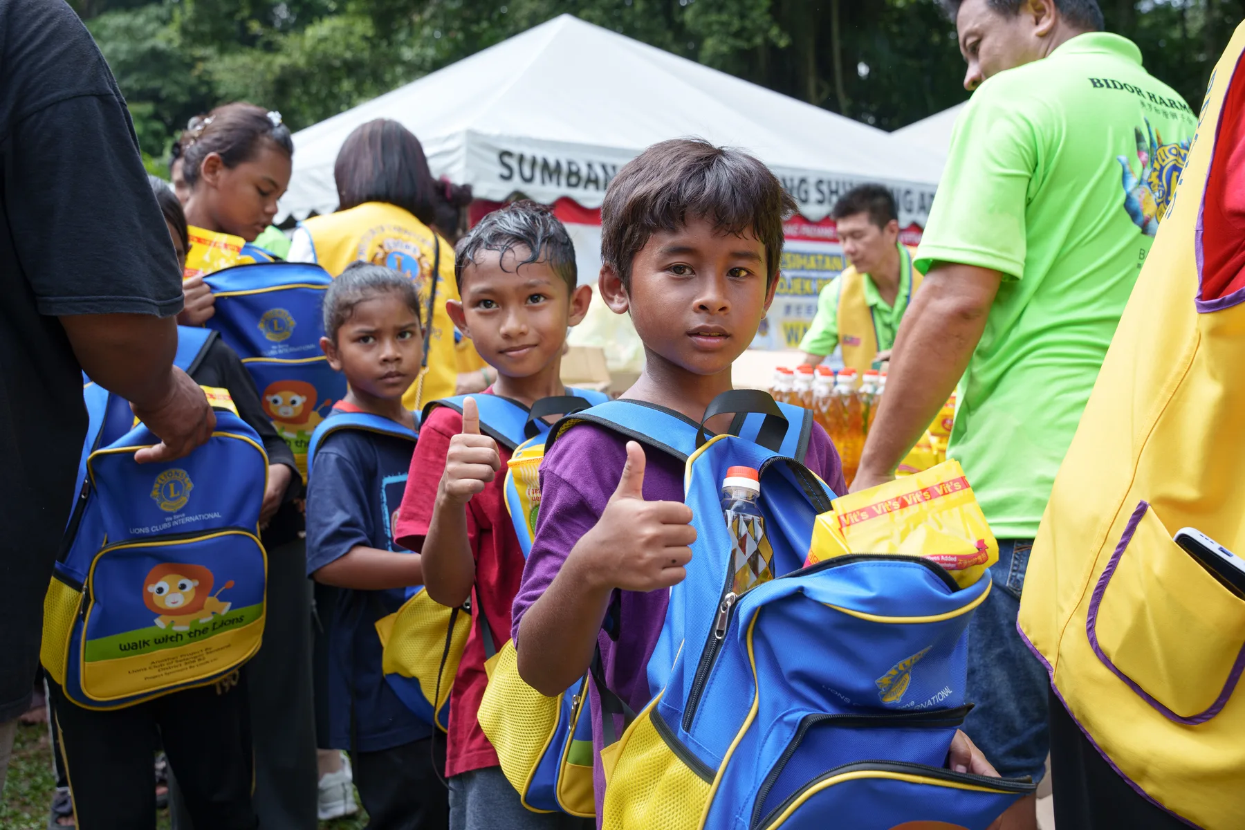 Village children showing the school bags and supplies they received
