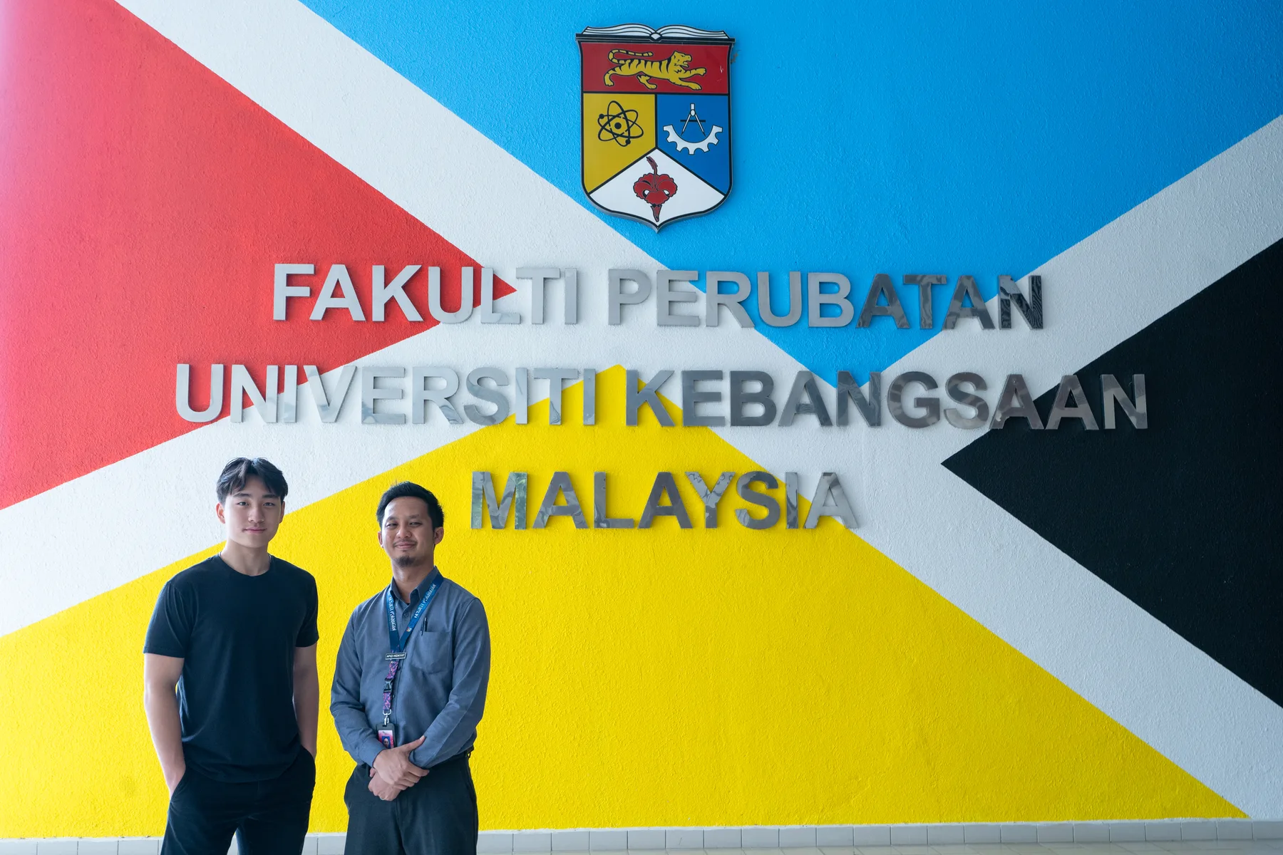 Louie and a UKM representative standing at the Faculty of Medicine sign