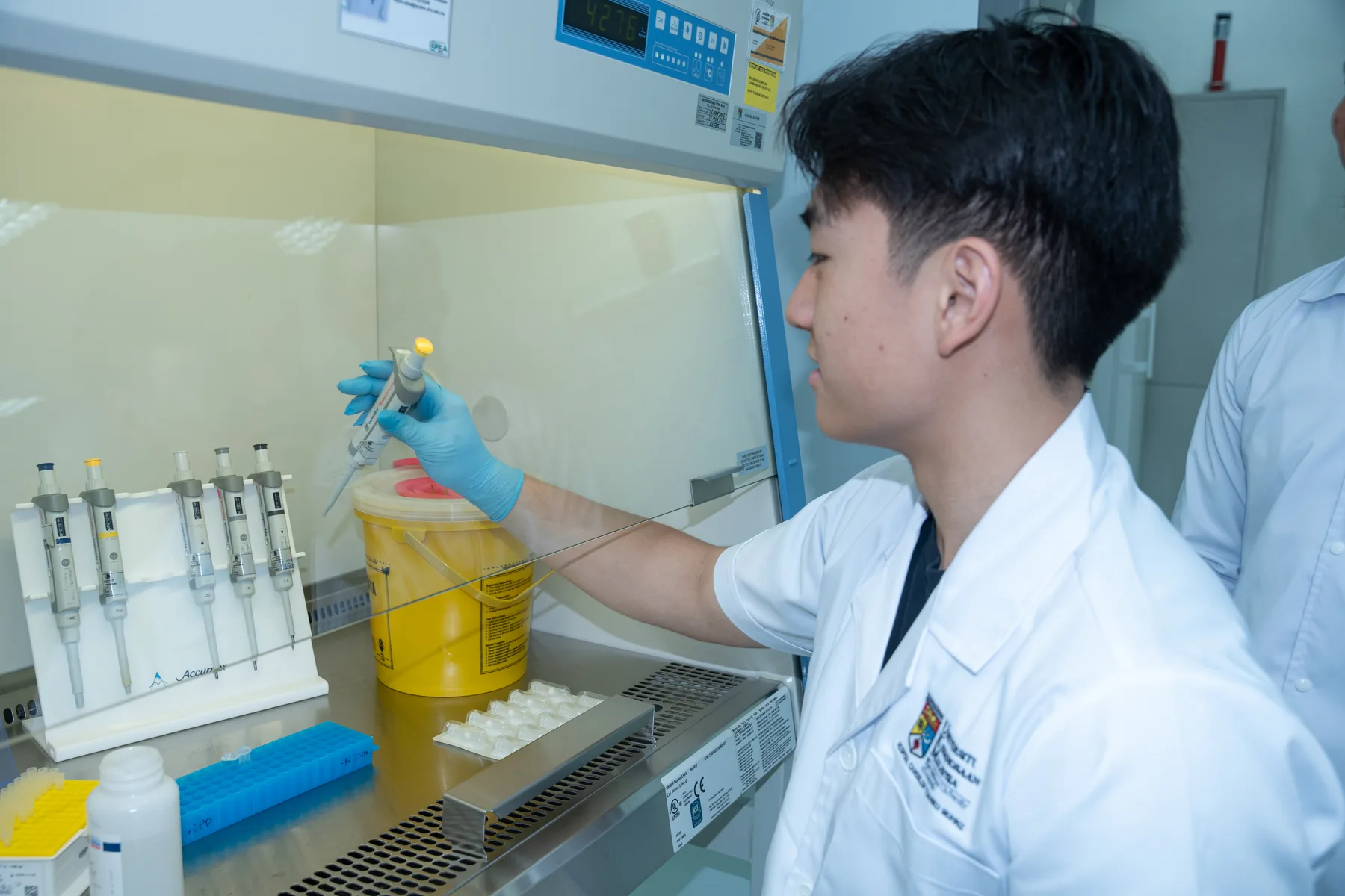 Louie handling a sample under the guidance of the UKM team
