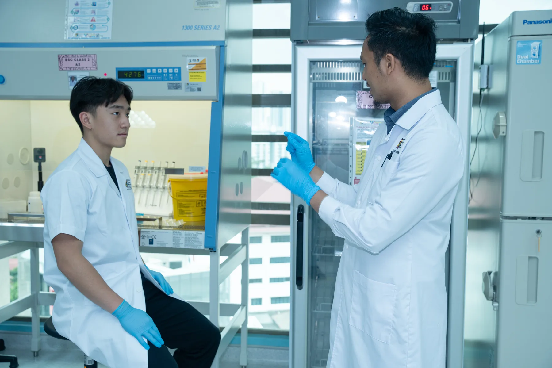 A UKM researcher explaining a laboratory procedure to Louie