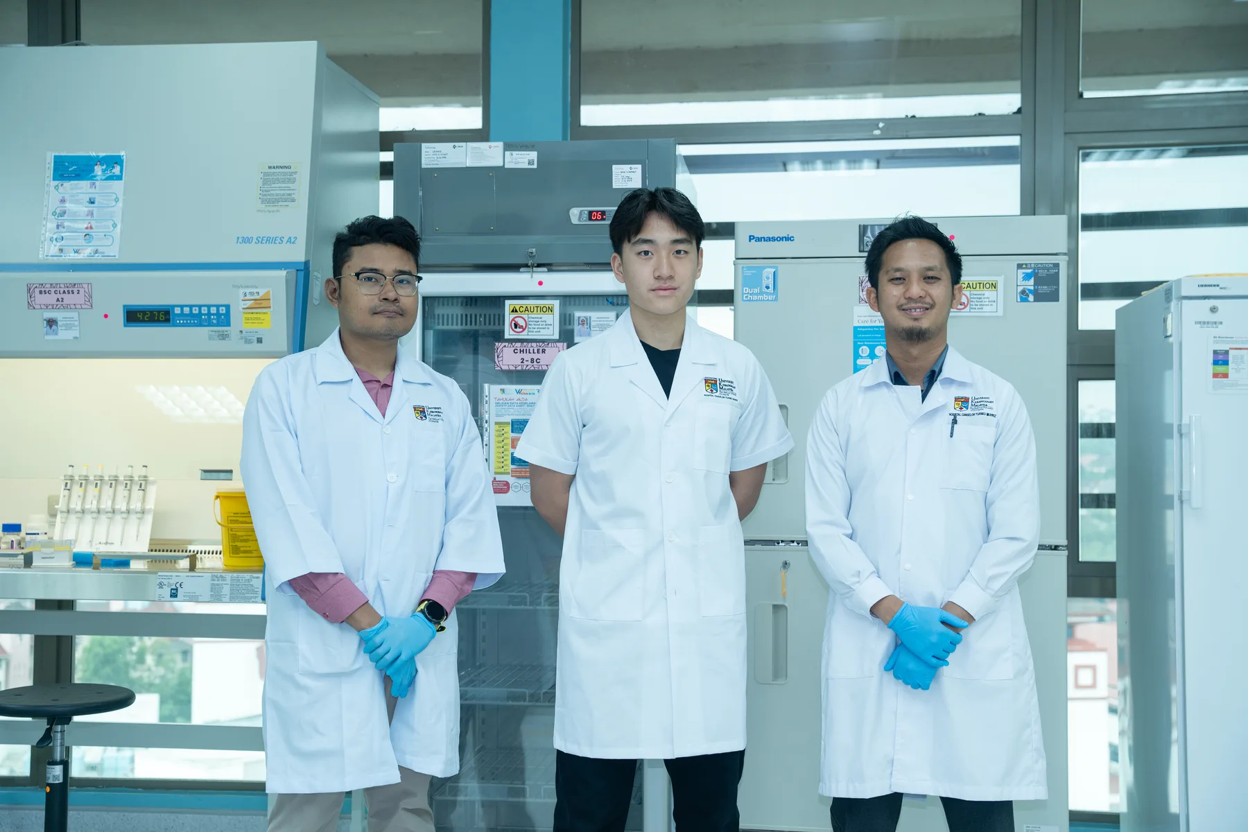 Louie standing with two members of the UKM laboratory team