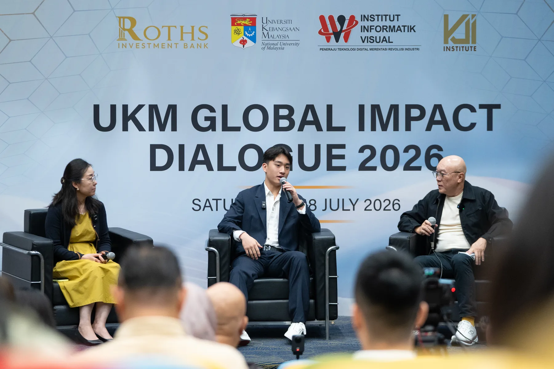 Louie Liu speaking with panel guests on the Global Impact Dialogue stage