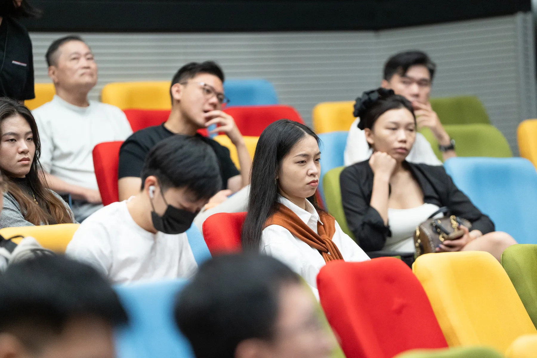 Students listening from the colourful auditorium seats