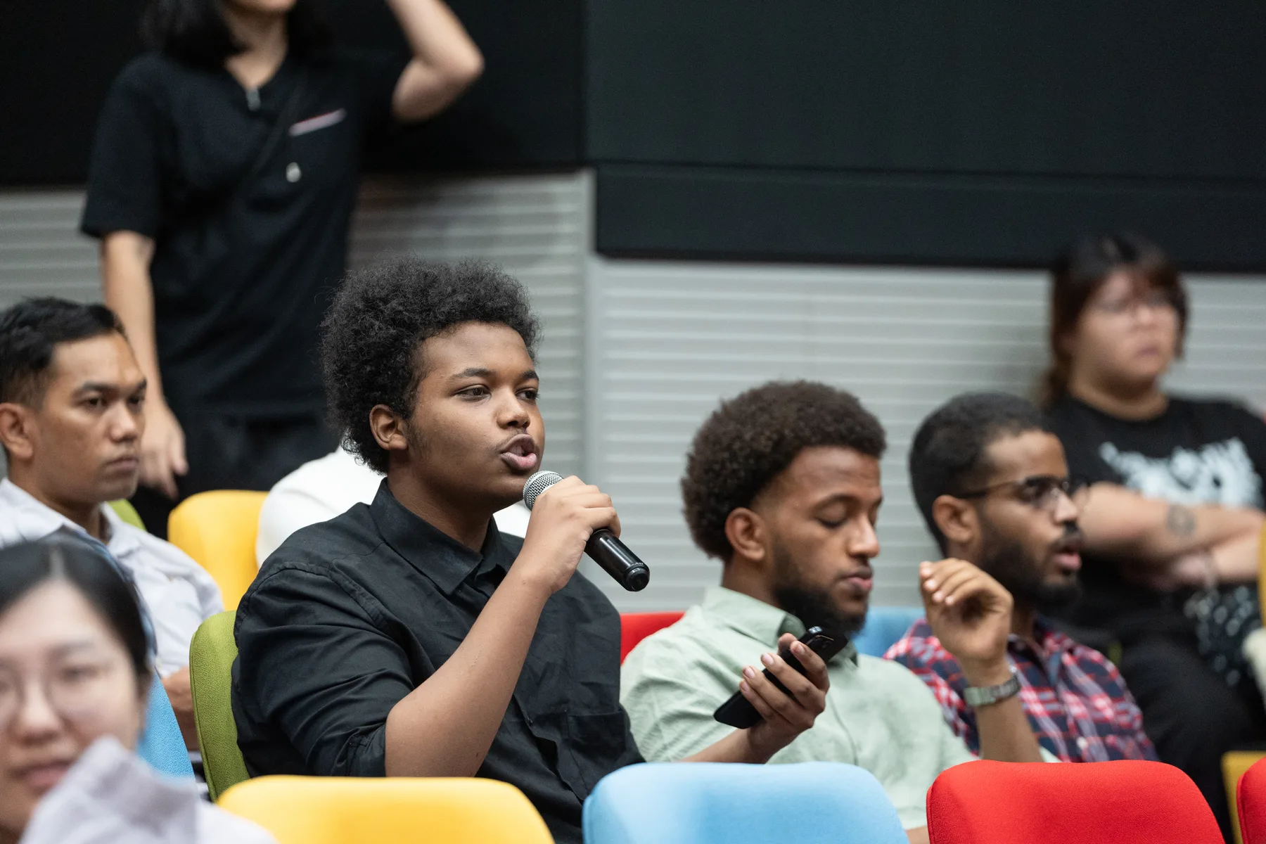 A student asking a question during the Global Impact Dialogue