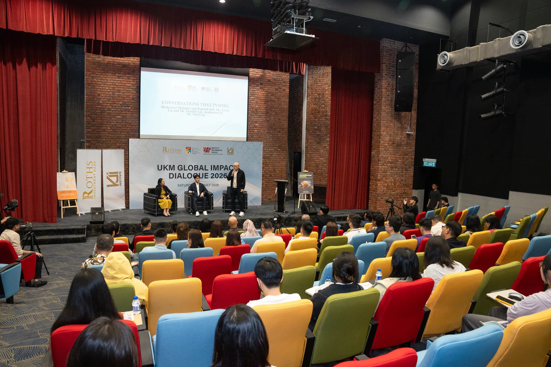 A wide auditorium view of the UKM panel conversation