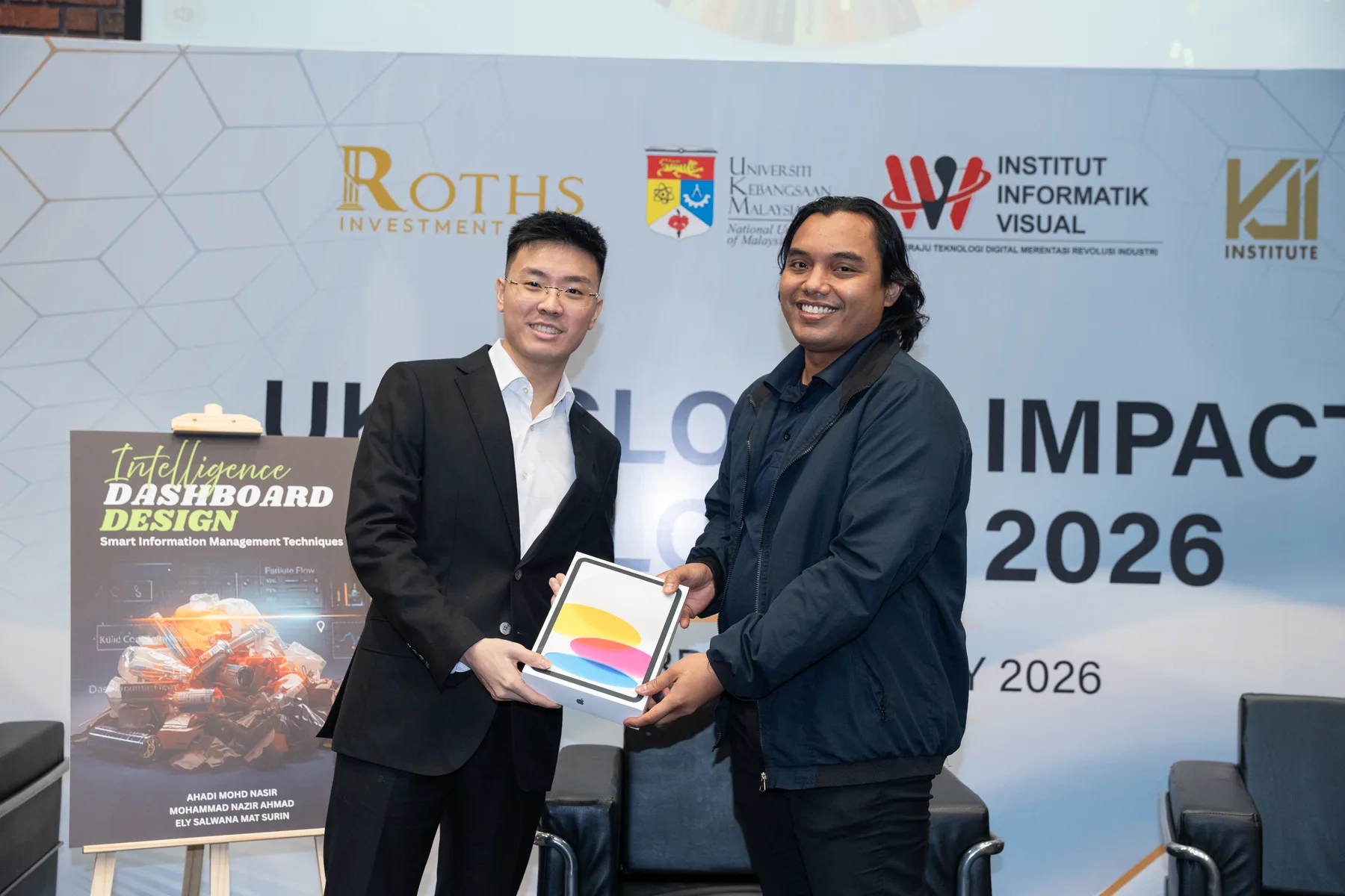 Two guests exchanging a leadership book at the UKM dialogue