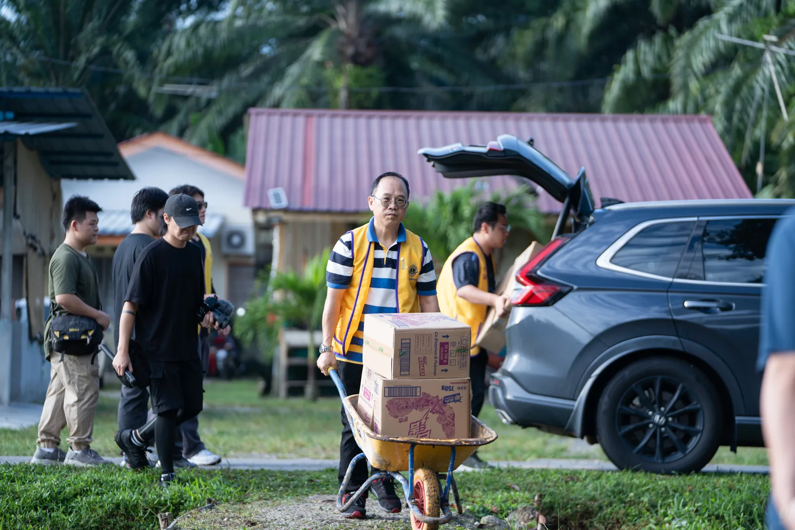 Volunteers welcoming children and distributing school bags