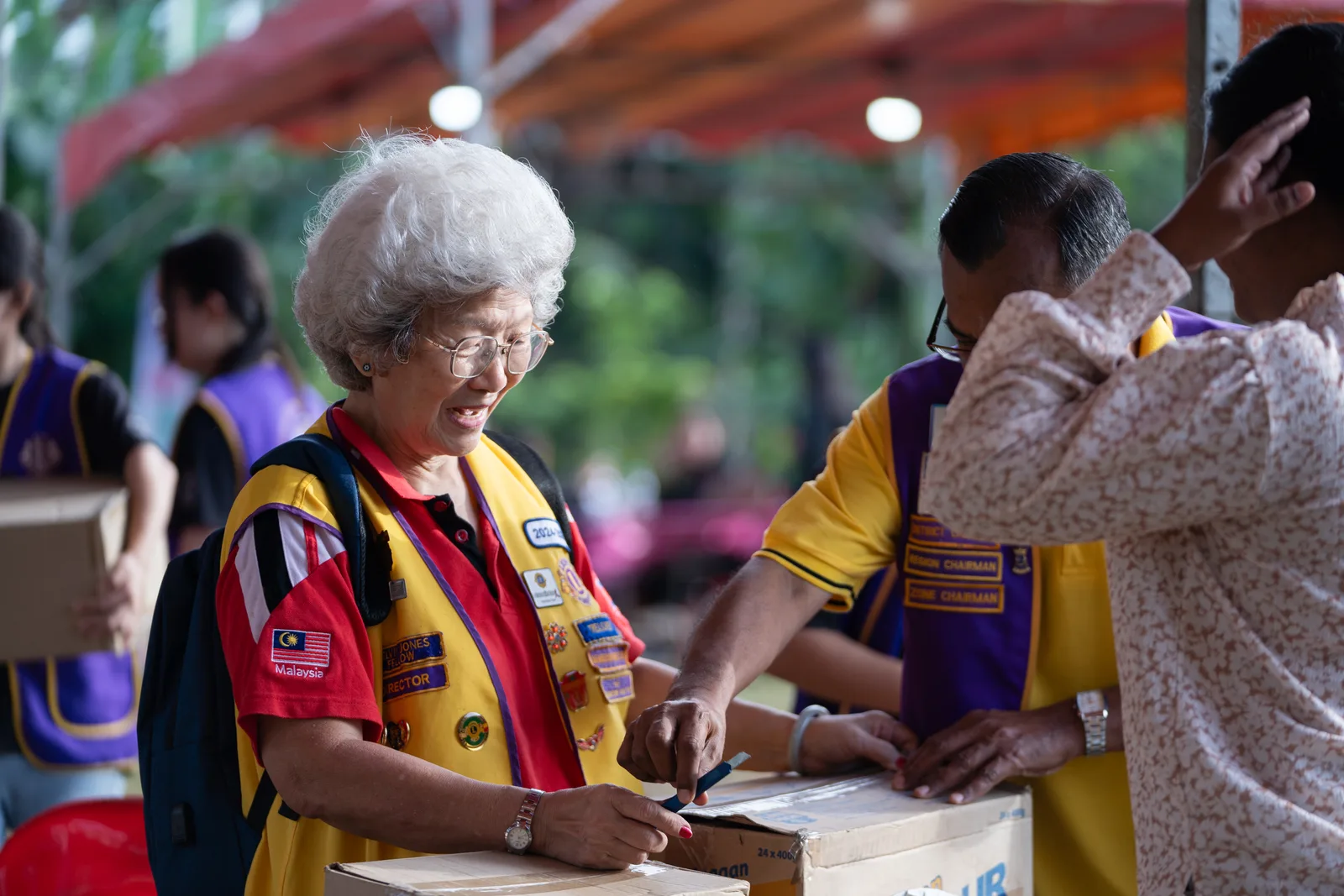 Children receiving colourful school bags from volunteers