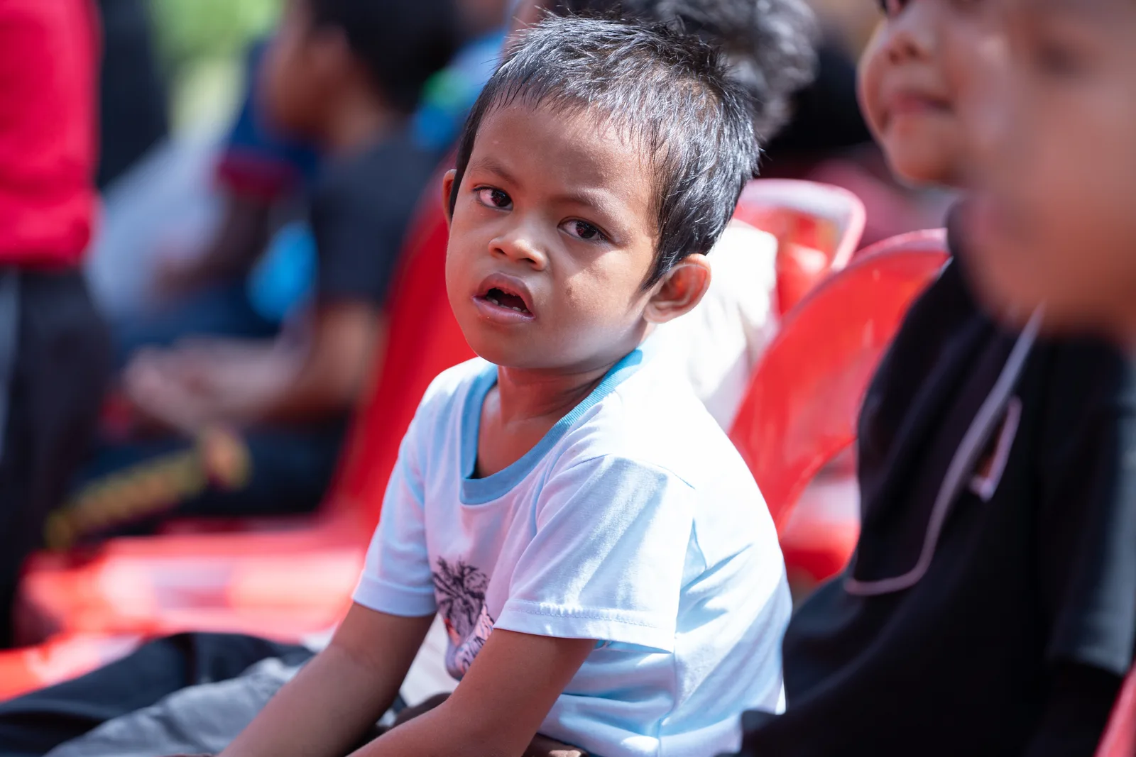 A volunteer helping a child during a health screening