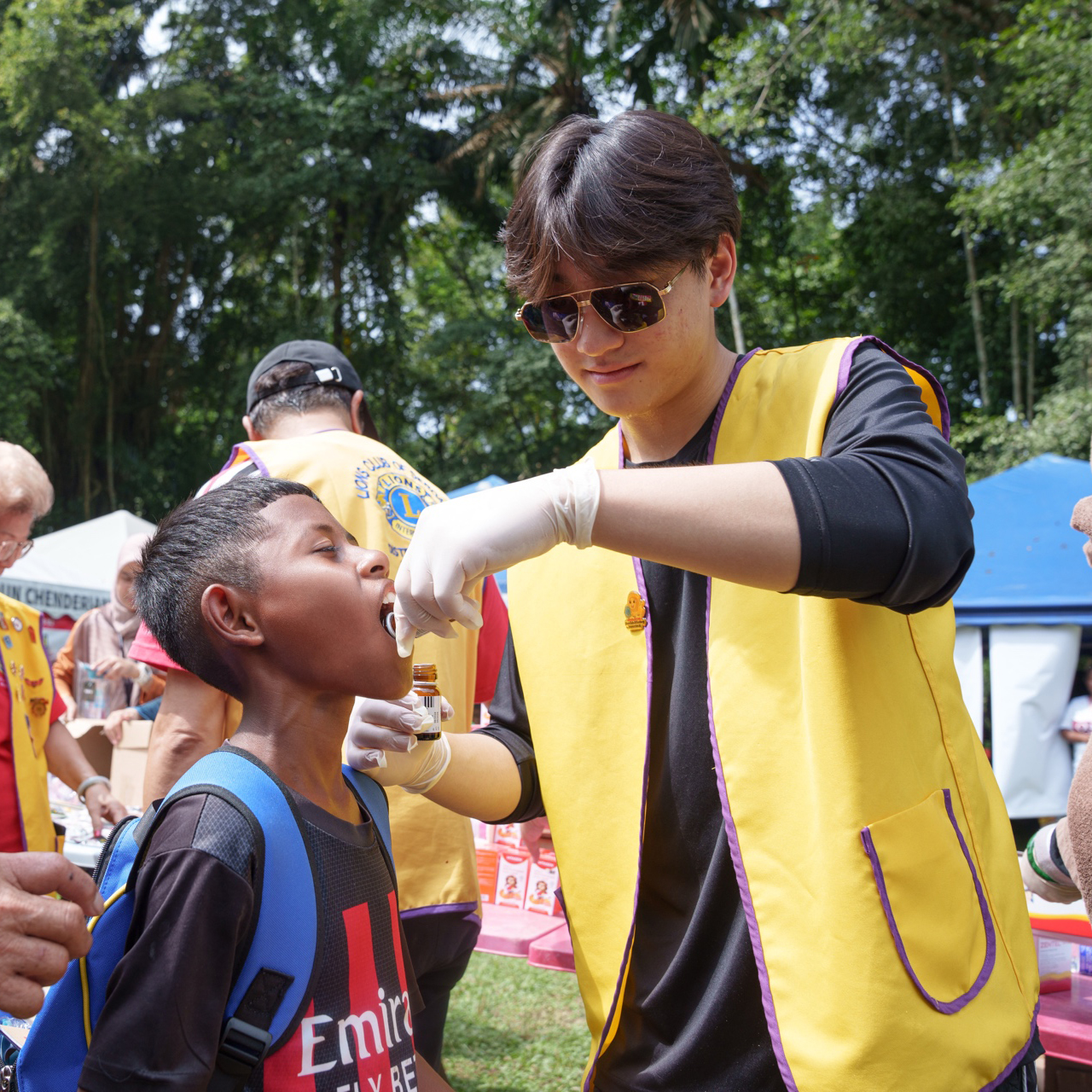 Louie administering health support to a child during the village outreach